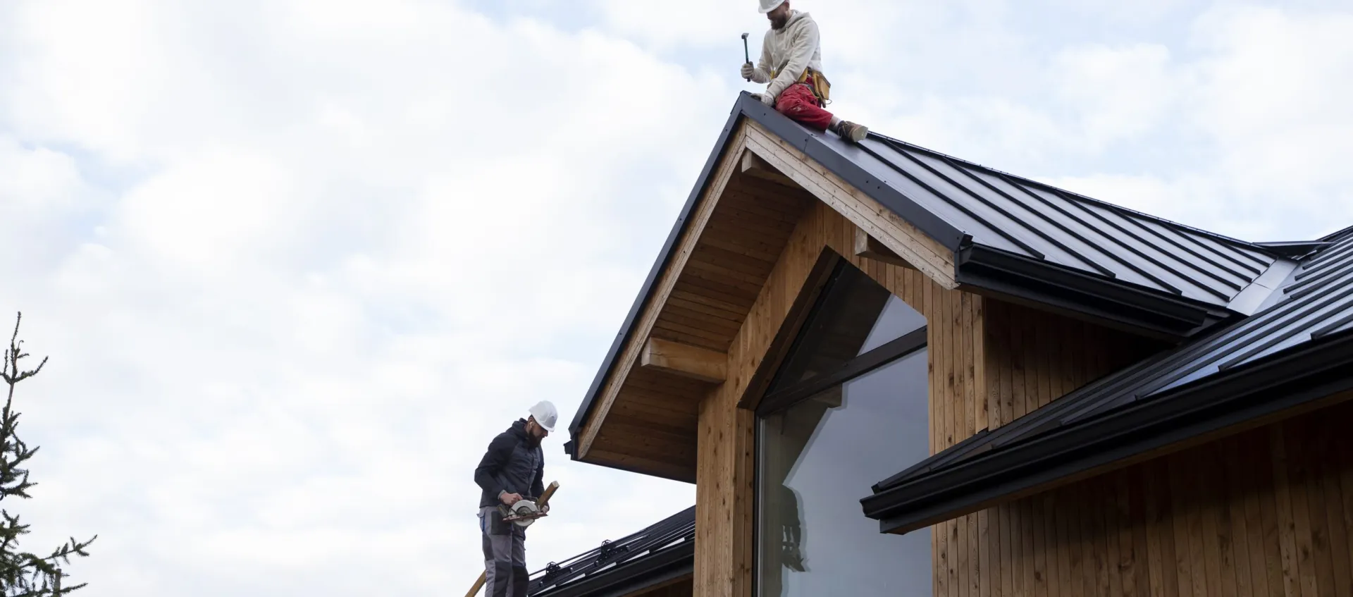 Artisans travaillant sur la toiture d’une maison à ossature bois