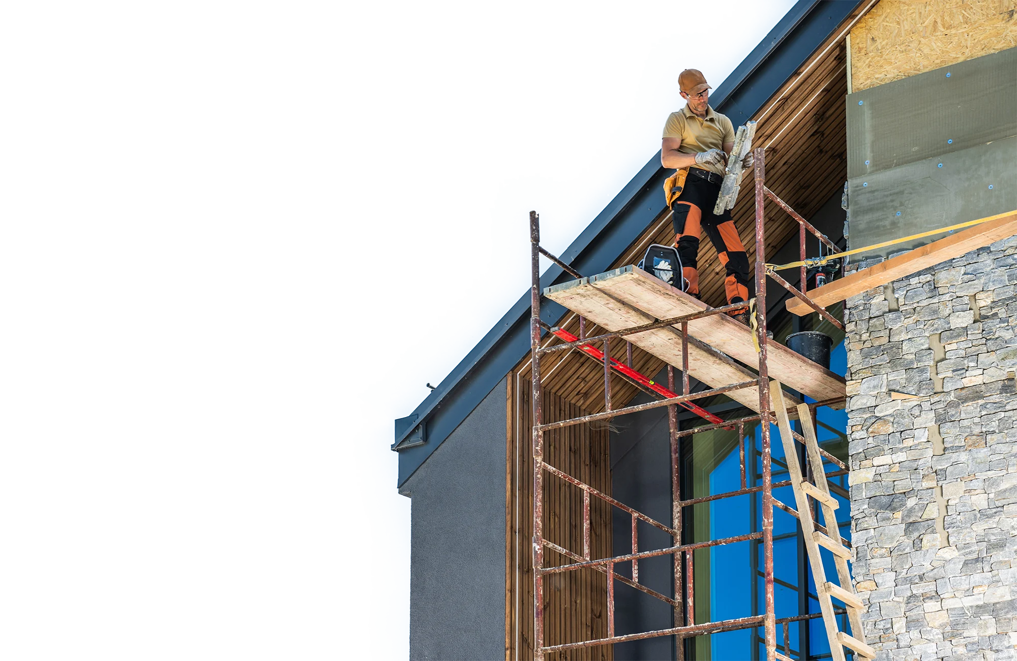 Façadier sur un échafaudage devant une façade en cours d’habillage