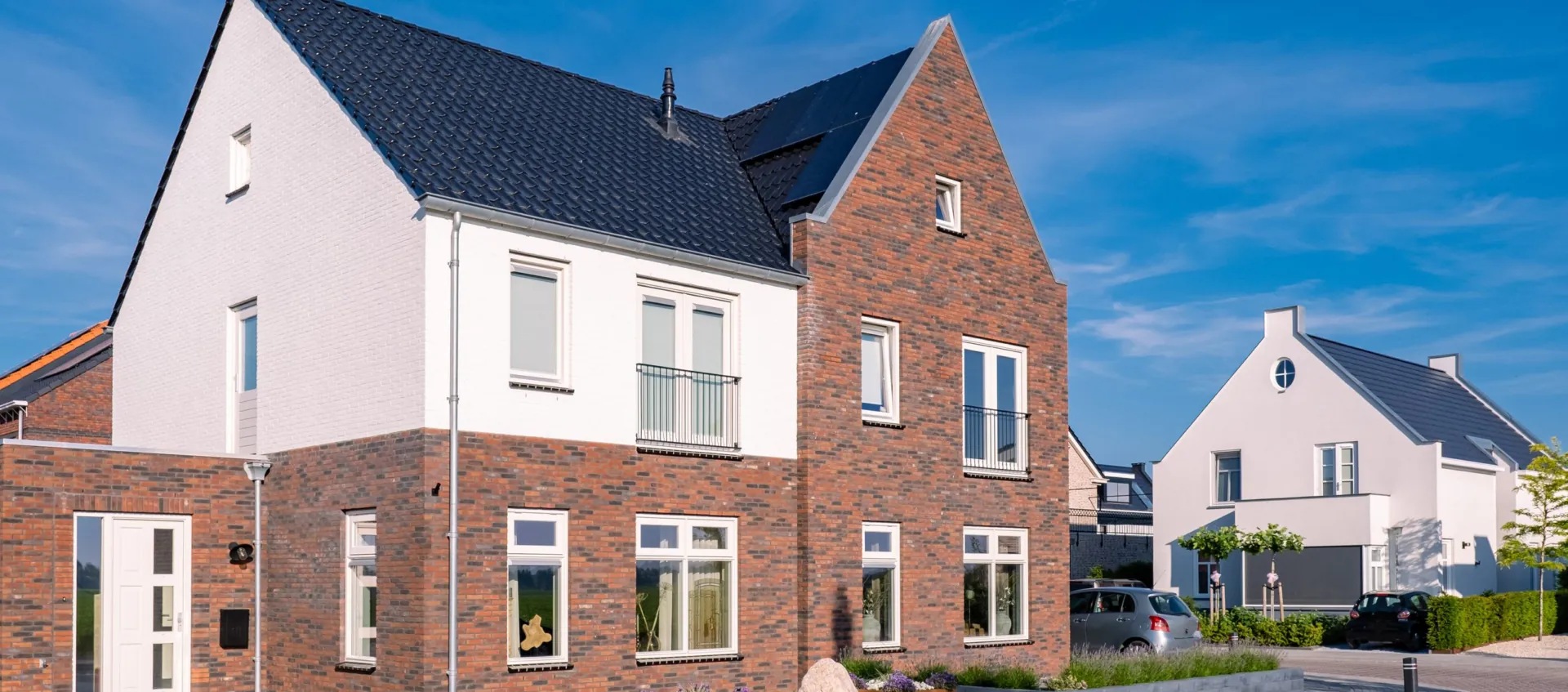 Maisons rénovées en briques et enduit blanc sous un ciel bleu