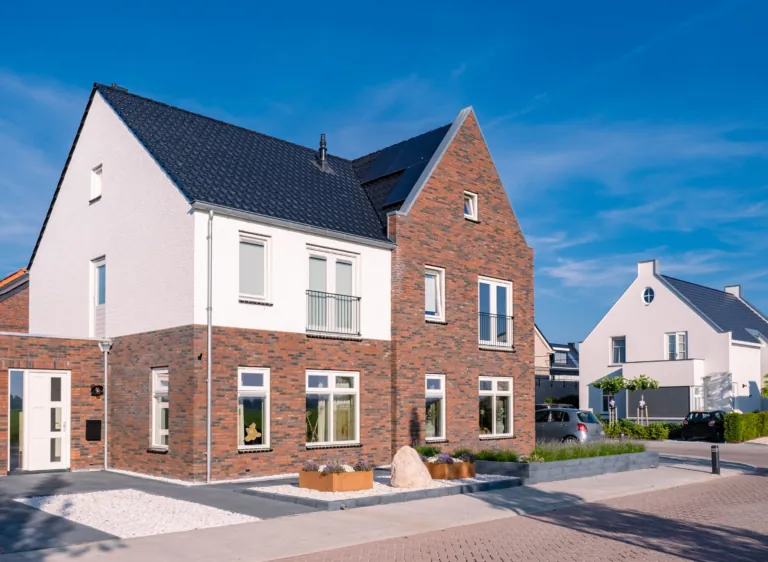 Maisons rénovées en briques et enduit blanc sous un ciel bleu