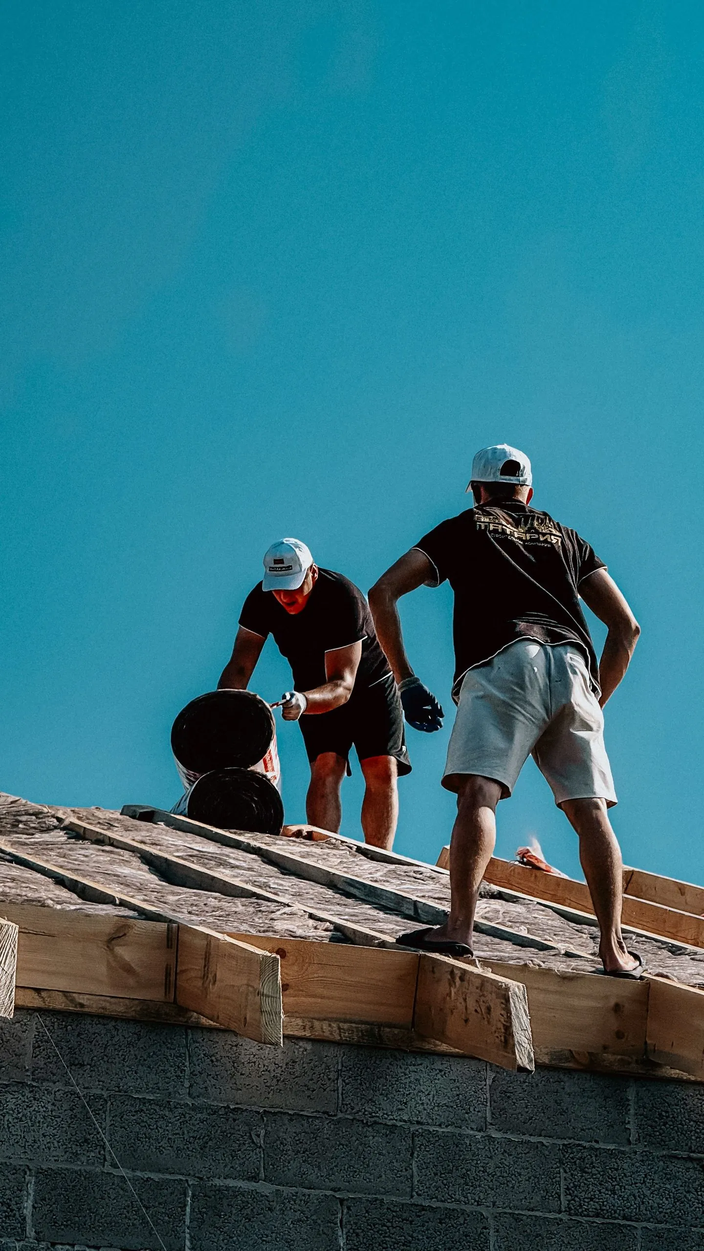 Deux ouvriers travaillant sur une toiture
